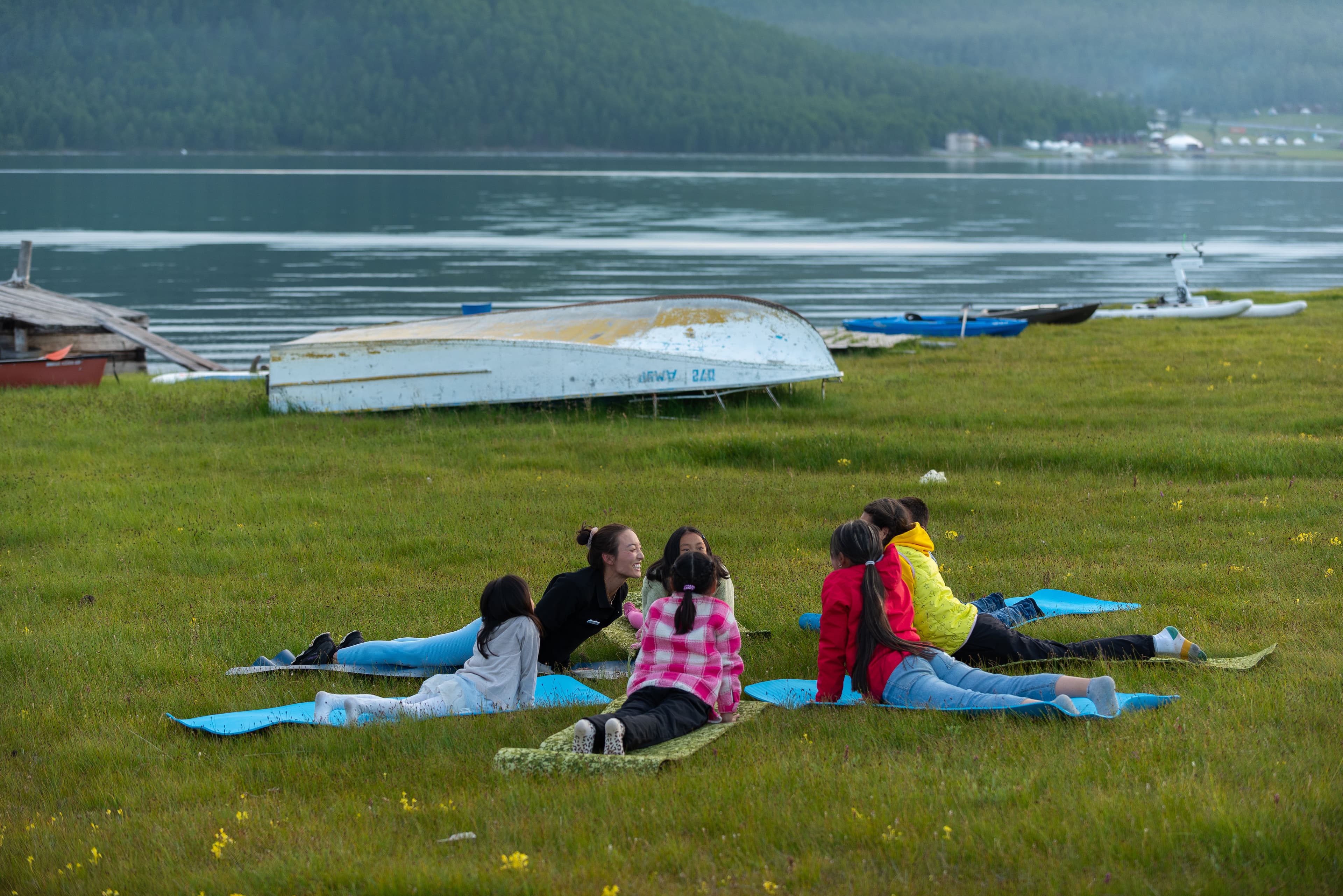 Children practicing yoga on the grass beside Lake Khuvsgul.