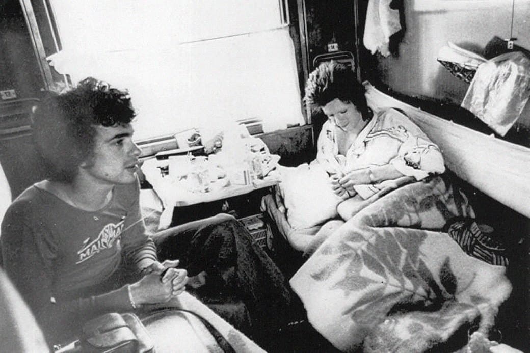 Black and white archival photograph of David Bowie traveling in a sleeper cabin on the Trans-Siberian Railway.